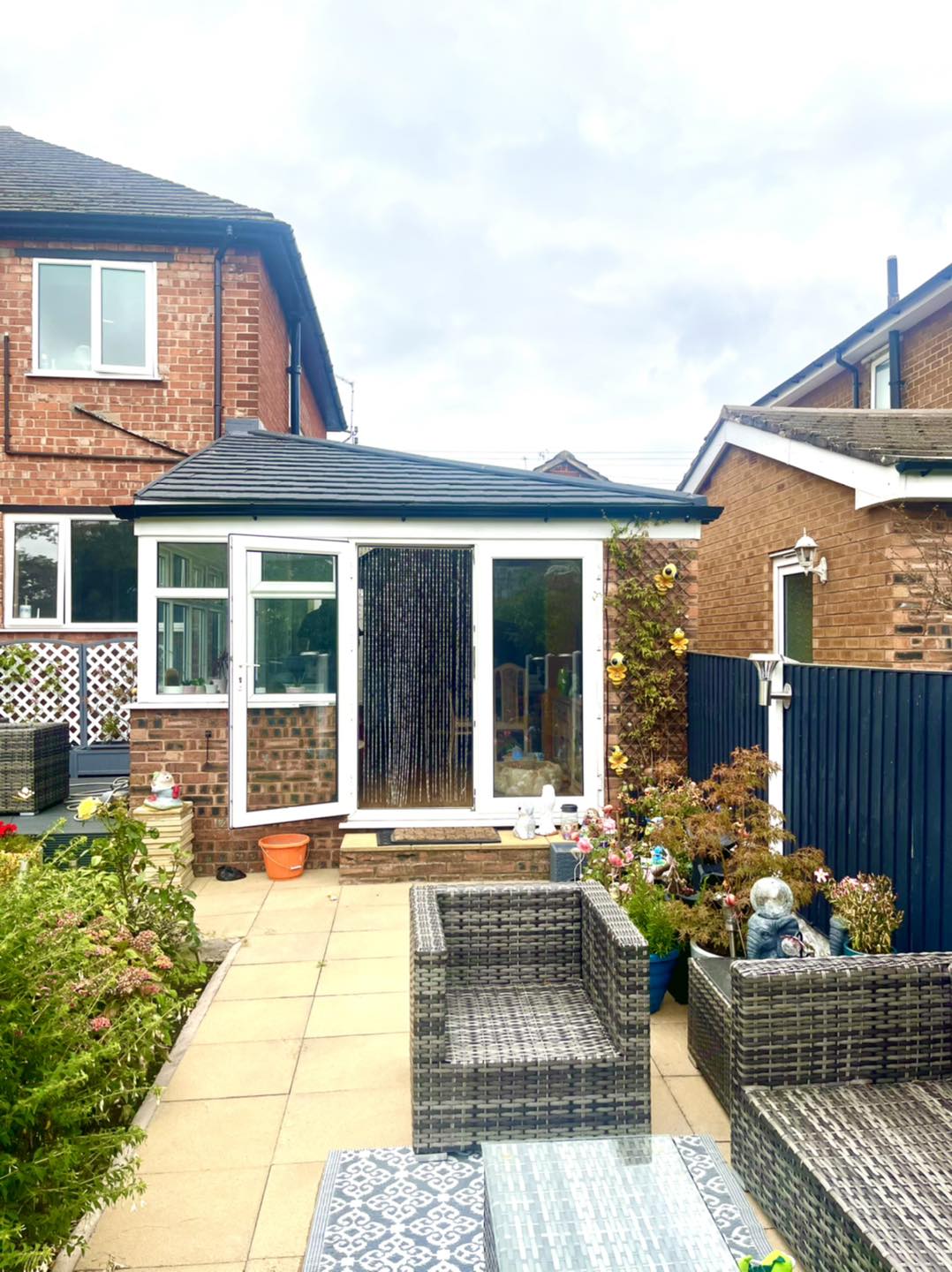 Interior of a converted conservatory with plastered ceiling and modern lighting